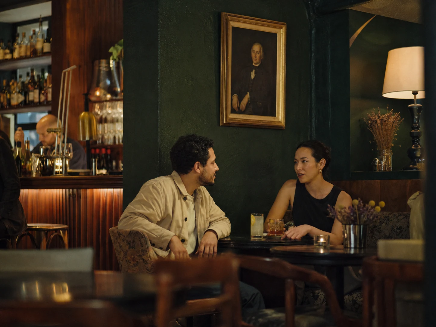 Two people having a relaxed conversation in a hotel bar